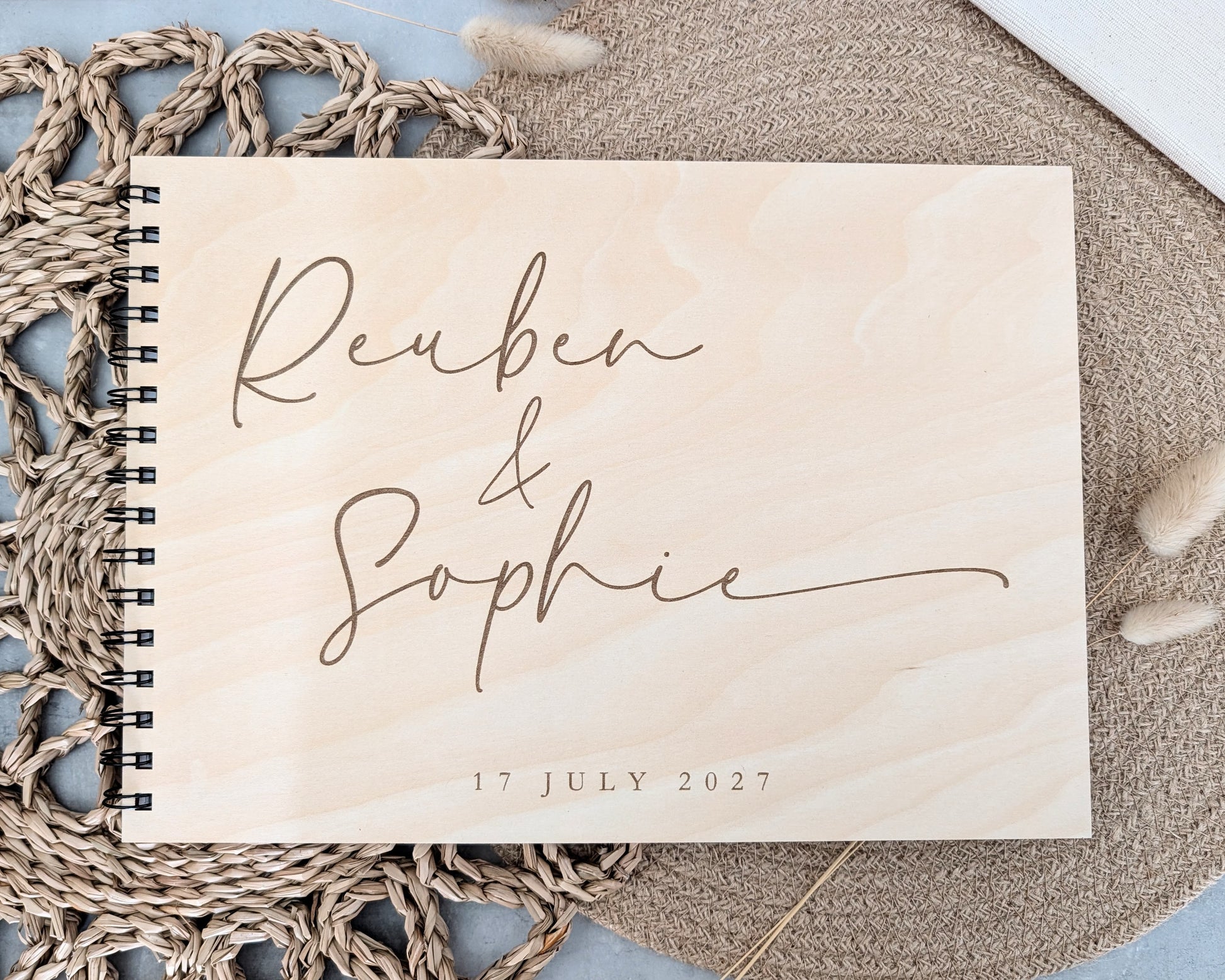 “Personalised wooden wedding guest book engraved with surname and date”

“Engraved basswood guest book with spiral binding”

“Rustic wooden wedding guest book on woven mat”