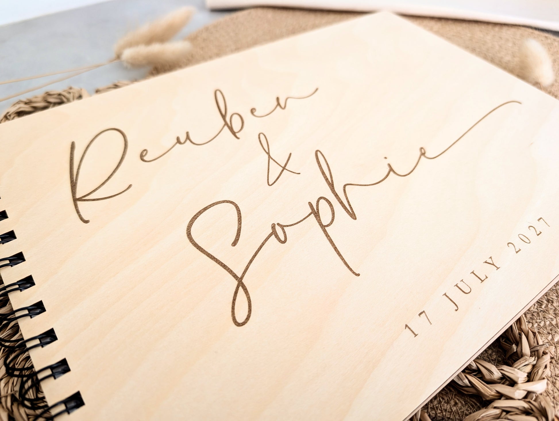 “Personalised wooden wedding guest book engraved with surname and date”

“Engraved basswood guest book with spiral binding”

“Rustic wooden wedding guest book on woven mat”