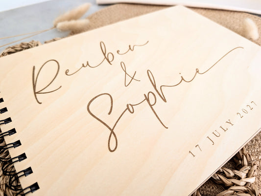 “Personalised wooden wedding guest book engraved with surname and date”

“Engraved basswood guest book with spiral binding”

“Rustic wooden wedding guest book on woven mat”