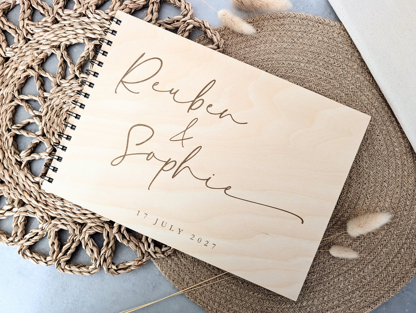 “Personalised wooden wedding guest book engraved with surname and date”

“Engraved basswood guest book with spiral binding”

“Rustic wooden wedding guest book on woven mat”