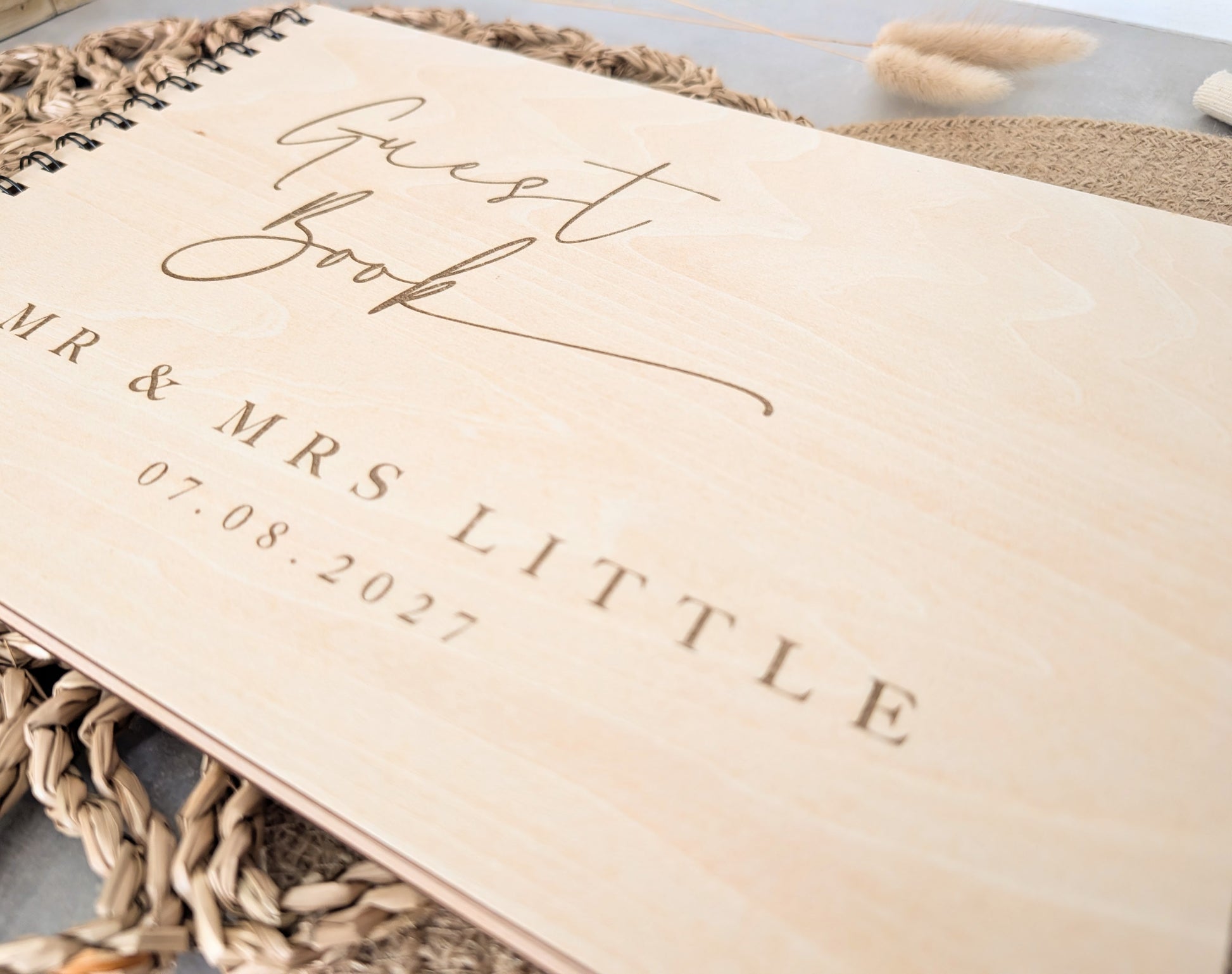 “Personalised wooden wedding guest book engraved with surname and date”

“Engraved plywood guest book with spiral binding”

“Rustic wooden wedding guest book on woven mat”

“Laser engraved basswood guest book cover”