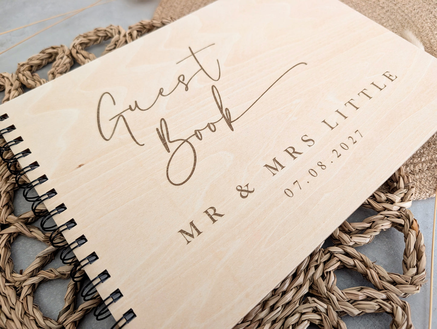 “Personalised wooden wedding guest book engraved with surname and date”

“Engraved plywood guest book with spiral binding”

“Rustic wooden wedding guest book on woven mat”

“Laser engraved basswood guest book cover”