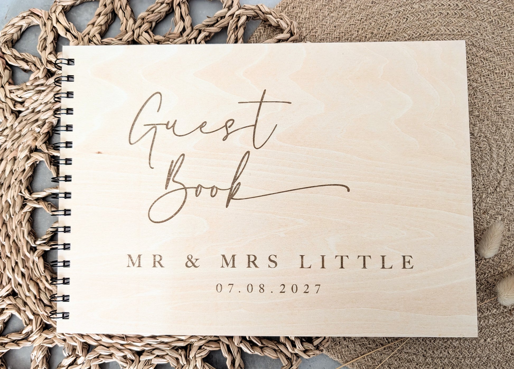 “Personalised wooden wedding guest book engraved with surname and date”

“Engraved plywood guest book with spiral binding”

“Rustic wooden wedding guest book on woven mat”

“Laser engraved basswood guest book cover”
